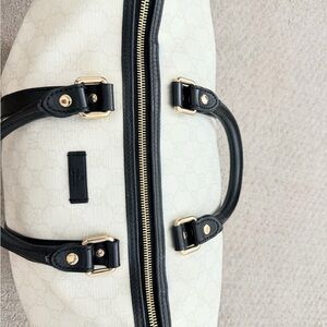 No longer for sale.

Gucci Women's Black and Cream Travel Bag